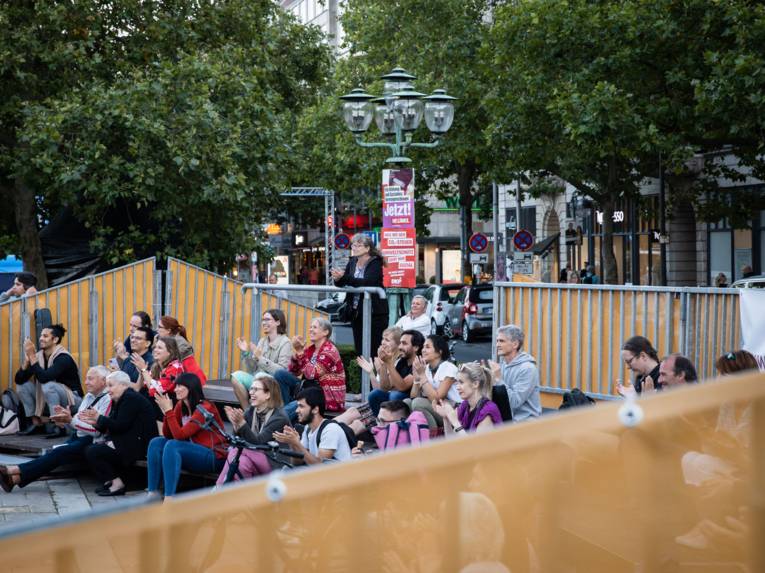 Menschen im öffentlichen Raum, die Musik lauschen.